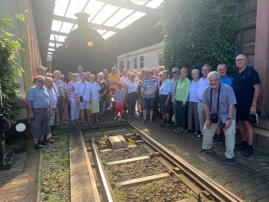 Die Volontäre vor einer alten Dampflokomotive