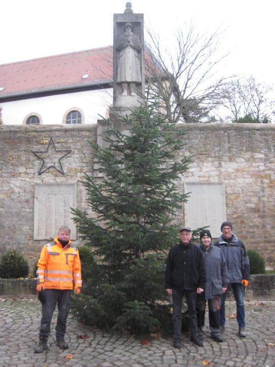 Volontäre vor dem Gemeinde-Weihnachtsbaum