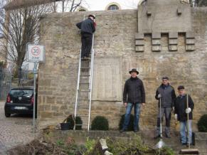 Fleißige Helfe beseitigen den Efeubewuchs und überbordender „Wilder Wein“ an der Frontmauer des Ehrenmals 