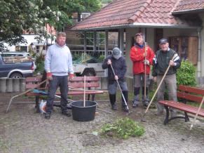 Eine Arbeitsgruppe sorgt auf dem Dorfplatz für Ordnung und Sauberkeit
