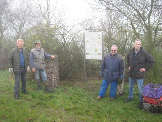 Volontäre befestigen Hinweißschild