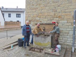 Volontäre reinigen den Brunnen