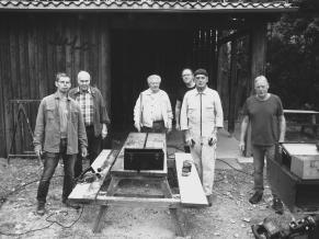Eine Gruppe von Volontären am Bearbeiten einer verschmierten Tisch-Bank-Kombination