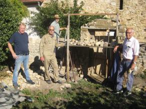 Volontäre vor der zu sarnierenden Mauer