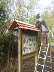Eine Infotafel bekommt ein neues Dach